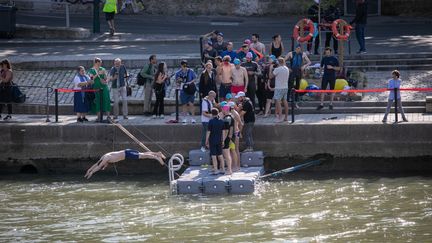 Des personnes participent &agrave; la baignade dans la Seine avec Anne Hidalgo, maire de Paris, le 17 juillet 2024, dans le centre de la capitale. (VICTORIA VALDIVIA / HANS LUCAS / AFP)