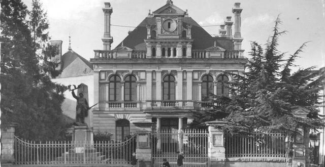 photo h&ocirc;tel de ville en fa&ccedil;ade ouest devant le champ de foire (future place charles-de-gaulle), avec son monument aux morts de la guerre 1914-1918 &eacute;rig&eacute; en 1922. &copy; archives 