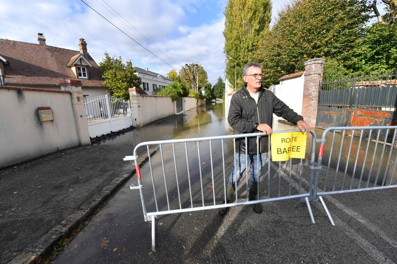 Un employ&eacute; installe une barri&egrave;re dans une rue inond&eacute;e &agrave; Villers-le-Morhier, le 10&nbsp;octobre 2024.