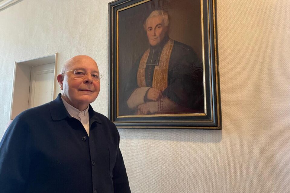 Le père José Antonini, ici devant le portrait de son illustre prédécesseur, dont la toile avait été retrouvé dans le grenier de l'église Saint-Louis en 2014