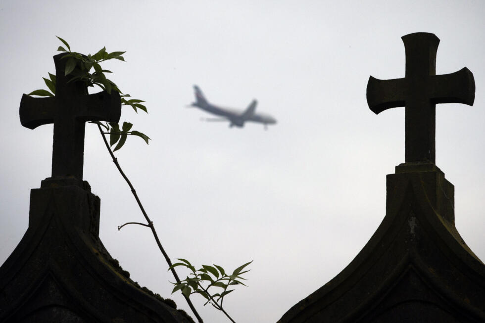 Un avion passe au-desusus du cimeti&egrave;re dans le village abandonn&eacute; de Goussainville, le 26 novembre 2013, dans le Val-d'Oise